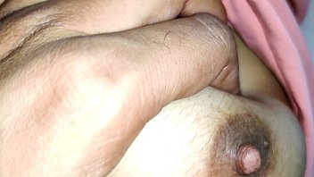 Молодая зрелая брюнетка обмазывает обворожительные ножки натуральной смазкой на кровати перед камерой